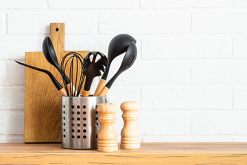 Kitchen utensils. Cooking tools with wooden cutting boards, oil and shaker at white modern kitchen...