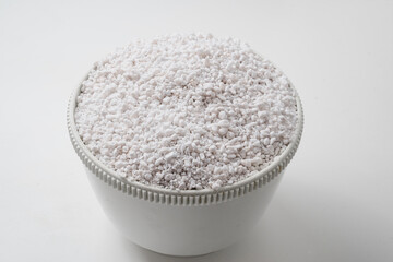 Perlite for plants in a bowl on a white background. 
