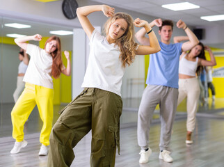 Fototapeta premium Teen girl in wide pants dancing hip hop dancing in dance studio