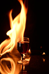 Obraz na płótnie Canvas shot of cognac drink with fire in the background glass of red wine