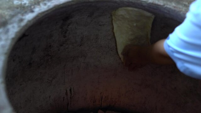 In the bakery, the baker prepares whole grain bread in the oven