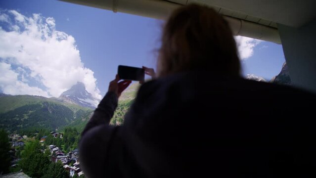 Balcony view Matterhorn female taking picture on phone