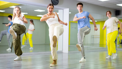 Energetic young girl engaging in breakdance in dance studio. Teenagers training Footwork moves