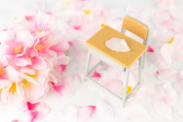 オモチャの勉強机と桜の花。入学、卒業、新学期イメージ