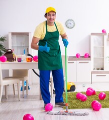 Fototapeta na wymiar Young male contractor doing housework after party