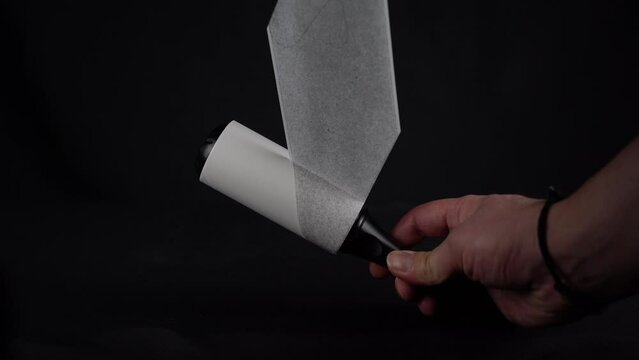 Roller for cleaning clothes from pet hair isolated on black background, close up
