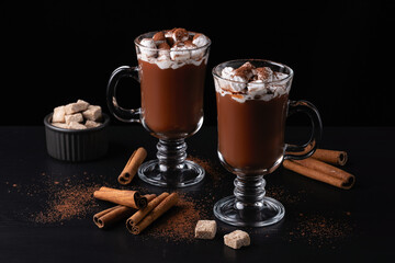 Two cups of hot chocolate, cocoa or warm drink with marshmallows on dark background
