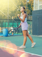 European woman serving ball while playing tennis in court during training