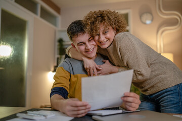 mature woman and son caucasian man teenager receive letter read good news student get scholarship...