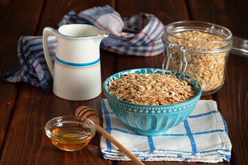 Oatmeal porridge in ceramic bowl decorated with fresh berries served with honey. Healthy breakfast concept.