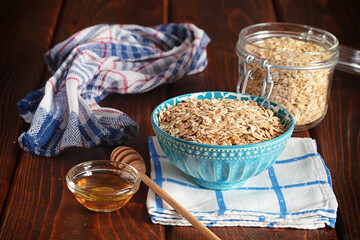 Oatmeal porridge in ceramic bowl decorated with fresh berries served with honey. Healthy breakfast concept.