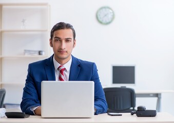 Young male businessman sitting in the office