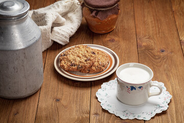 homemade cookies and cup of milk on wooden table