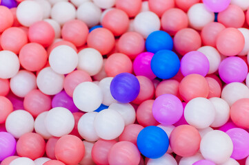 Background, texture of a large pile of colored, multi-colored round plastic small balls on the playground for children's games. Photography, top view, copy space, childhood concept, macro.