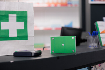 Green screen mock up chroma key pills packages standing on drugstore counter desk in empty pharmacy. Health care store filled with pharmaceutical products and medicaments bottles, medicine concept