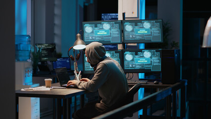 IT fraud criminal hacking security system to steal big data, doing cyberattack and ransomware. Coding virus to create malware and break into database servers, using multiple monitors.