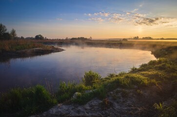 Naklejka na ściany i meble Beautiful morning foggy landscape. Sunrise over the river in Ponidzie in Poland.