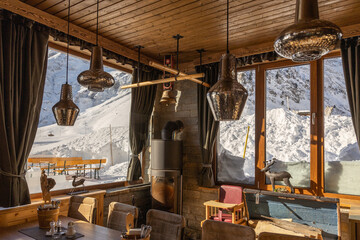 Corner of an authentic Alpine restaurant with wooden finishes, fireplace and panoramic mountain views, Austria, Salzburg