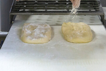 Raw dough is being sprinkled with flour. Process of making homemade pastry