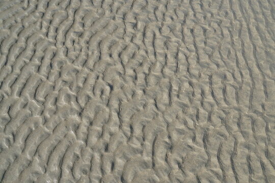 Wet sand texture left by water, abstract natural scene on a sandy beach shore, Spain