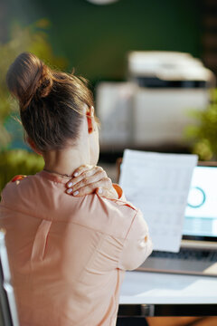 Seen from behind modern business woman having neck pain