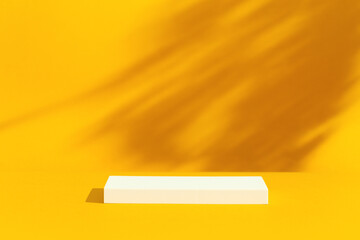 Stage, podium for products or cosmetics on yellow background with leaves shadows. Product display background.	
