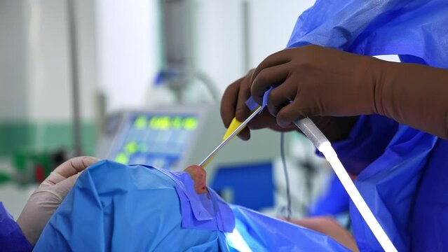 Unrecognized otolaryngology surgeon uses tools in patient’s nose. Doctor uses instruments to perform rhinoplasty. Close up.