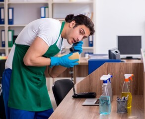 Young handsome contractor cleaning the office