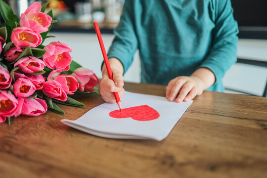 Child draws a heart for mom on mother's day