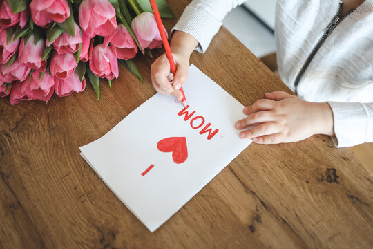 Child draws a card for mom on Mother's Day