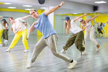 Energetic teenage boy engaging in breakdance in dance studio. Teenagers training Toprock moves