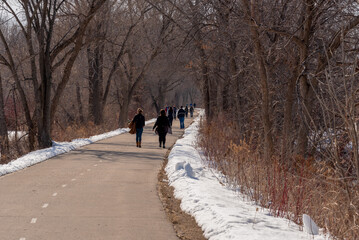 Fototapeta na wymiar Walkers Enjoying The Fox River Trail In De Pere, Wisconsin, In Warm Winter Weather