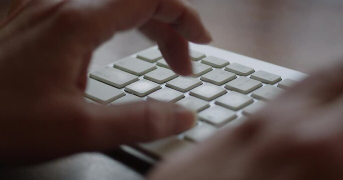 Locked Close-up of a woman's fingers typing on a computer keyboard. Blackmagic Cinema Camera 6K Pro with natural light. 4K ProRes 422 HQ DCI 4096 x 2160. Color graded in DaVinci Resolve.  