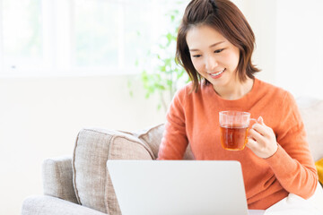 部屋でラップトップコンピューターを見る女性