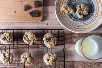 Top view of chocolate chip cookies on a rack and other broken cookies on a plate.