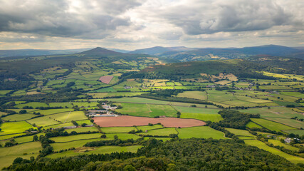 Obraz premium Aerial view of rural farmland and fields in a hilly area (South Wales)