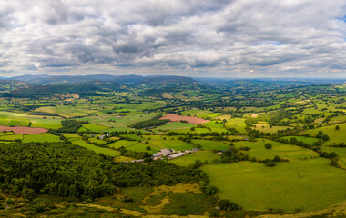 Aerial view of rural farmland and fields in a hilly area (South Wales)