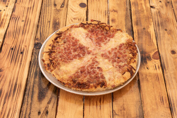 A curious deep-dish pizza with cheese and lots of fried bacon and onion tacos