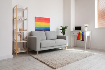 Interior of living room with workplace, LGBT flag and painting