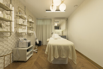 Aesthetic treatment room with a relaxation table, creams and appliances to apply massages and cleanings