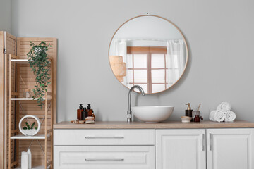 Interior of light bathroom with counters, sink and mirror