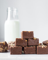 chocolate fudge with nuts on a marble tray, chocolate fudge cut into pieces, fudge candy on a marble tray