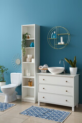 Fototapeta na wymiar Interior of bathroom with white sink, drawers and shelving unit