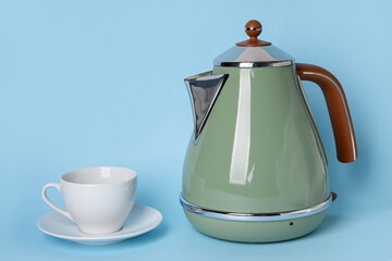 Electric kettle and cup on blue background