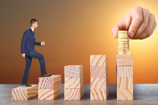 Steps To Success. Businessman Climbing Up Stairs Of Wooden Blocks To Reach Wealth. Man Stacking Coins On Top, Closeup