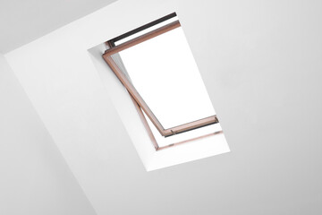 Open skylight roof window and lamps on slanted ceiling in attic room, low angle view © New Africa