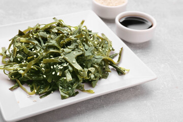 Fresh laminaria (kelp) seaweed served on light gray table, closeup