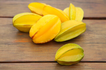 Delicious ripe carambolas on wooden table, closeup