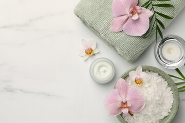 Fototapeta na wymiar Flat lay composition with different spa products and flowers on white marble table. Space for text