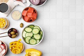 Ingredients for poke bowl on white checkered table, flat lay. Space for text